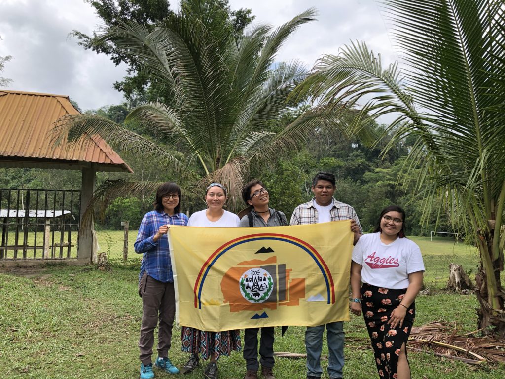 Diné delegates hold their flag representing the Navajo Nation outside of the Copal AA school. Photo credit: Chantelle John