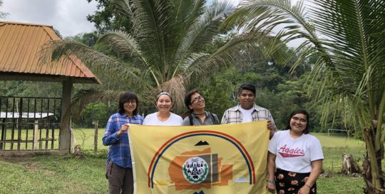 Diné delegates hold their flag outside of the Copal AA school. Photo credit: Chantelle John