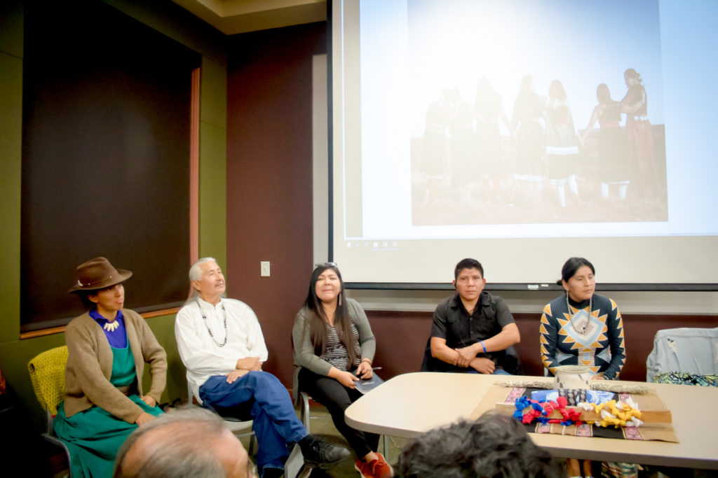 A photograph of Indigenous people sitting in a speaking panel. 