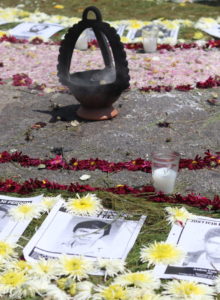 black and white pictures of guatemalan dessapeared are laying in the ground surrounded by flowers and candles