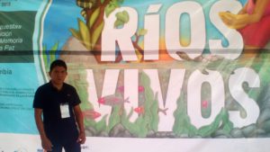 José Gómez stands in front of a sign that read RIOS VIVOS, or LIVING RIVERS.