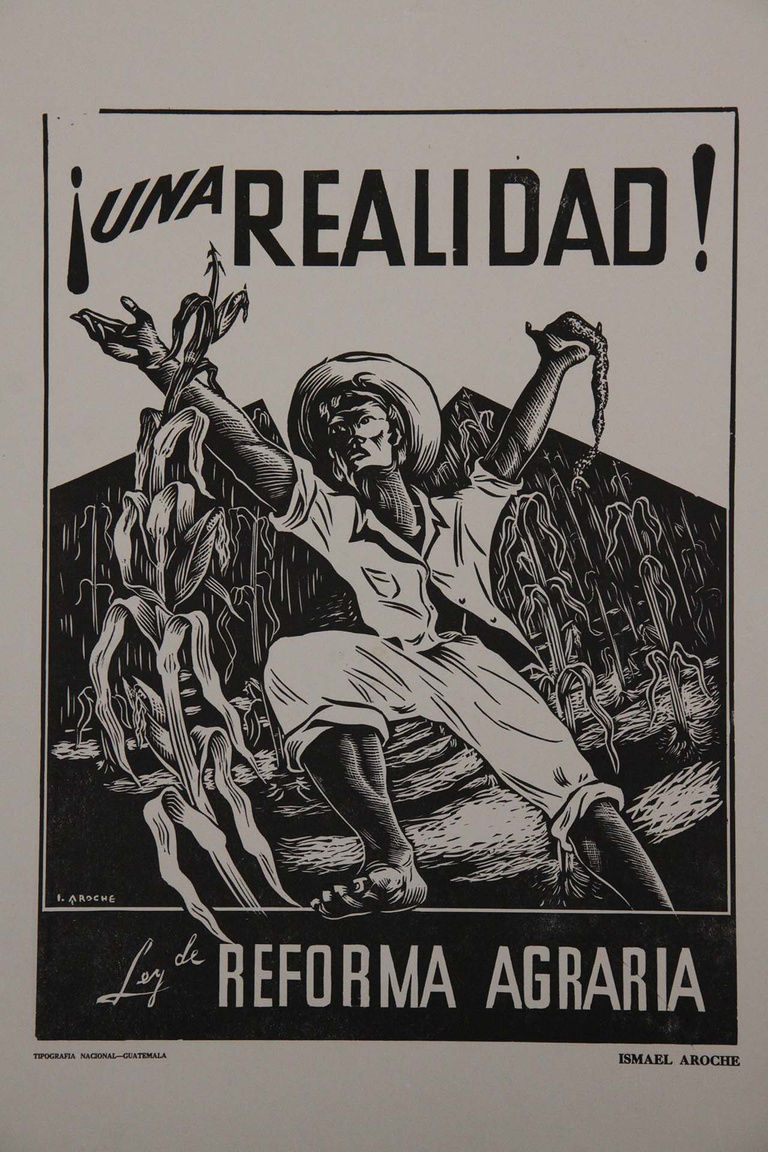 Image from an old poster that reads: “Una Realidad. Ley de Reforma Agraria” (A Reality: Agrarian Reform Law). There is a black and white image of an individual standing with arms raised in front of a field of corn. // Imagen de un viejo cartel que dice: “Una Realidad. Ley de Reforma Agraria”. Hay una imagen en blanco y negro de un individuo de pie con los brazos levantados frente a un campo de maíz.