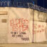 Image of a white cement wall with barbed wire on top of it, covered with red and black graffiti in Spanish that says: “The crime is 1954. No one is illegal on stolen land. Marco wants to be Rubio (blonde) just like Trump.”