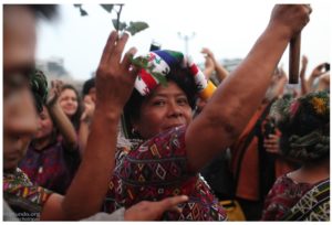 Indigenous mayor of Nebaj and Ixil Ancestral Authority, raises her baton as Ixil Maya survivors exit the courtroom following the guilty verdict issued against former Guatemalan dictator José Efraín Ríos Montt.