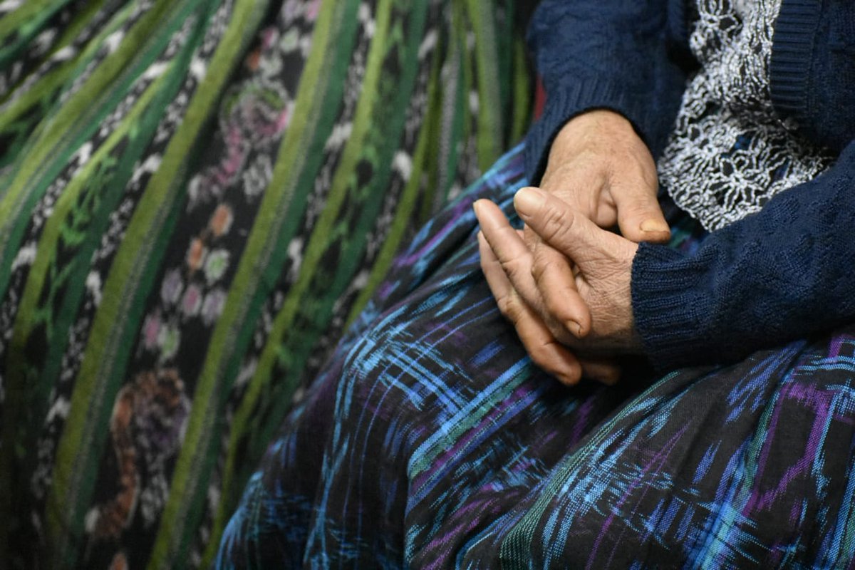 A woman folds her hands over her Mayan skirt, or corte.