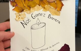 Hoja de papel con pétalos de rosa secos y las palabras “Noé Gómez Barrera, líder Xinka y defensor de derechos asesinado 28 de octubre 2023. #JusticiaParaNoé #NoMasViolencia.” Paper with dried rose petals and the words“Noé Gómez Barrera, Xinka leader and rights defender, assassinated October 28, 2023. #JusticeForNoé #NoMoreViolence.”