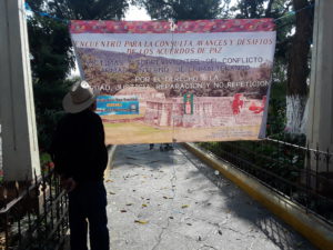 A person looks at a sign that says: "Victims and survivors of the Internal Armed Conflict in Chimaltenango for the right to truth, justice, reparations, and no repetition."